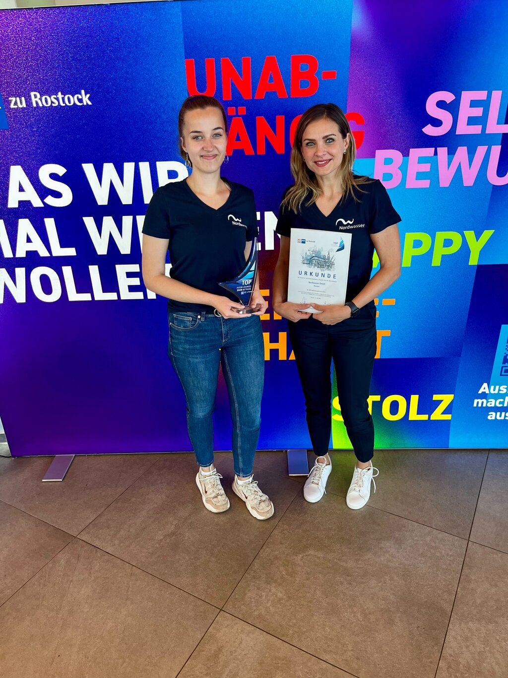 Zwei Frauen mit Pokal und Urkunde in der Hand