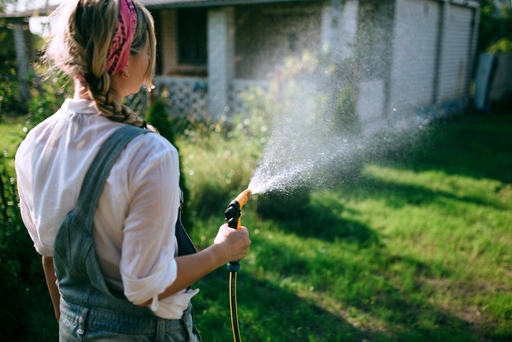 Frau gießt den Garten