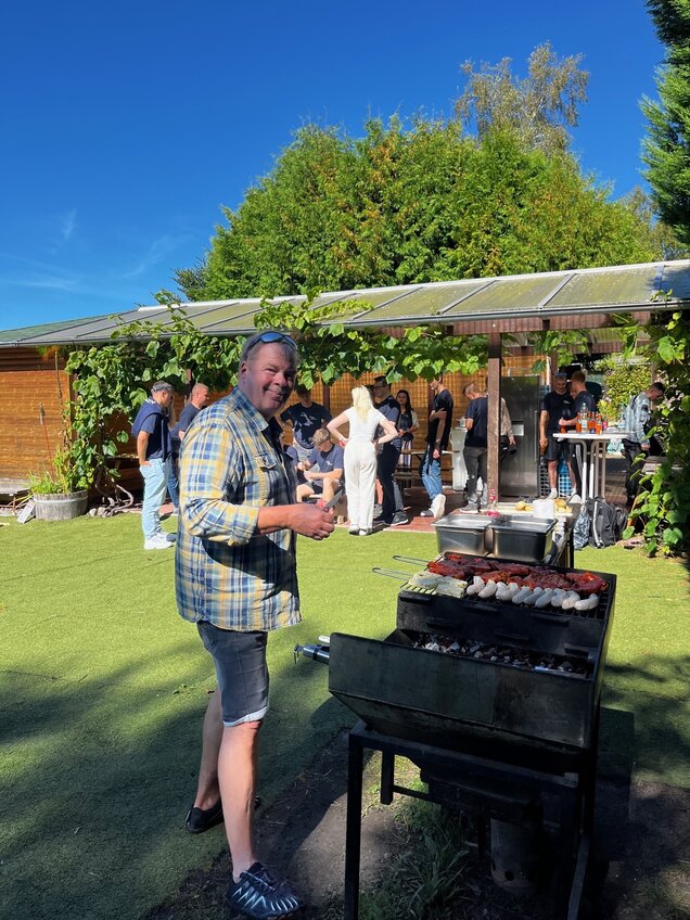 Mann steht am Grill 