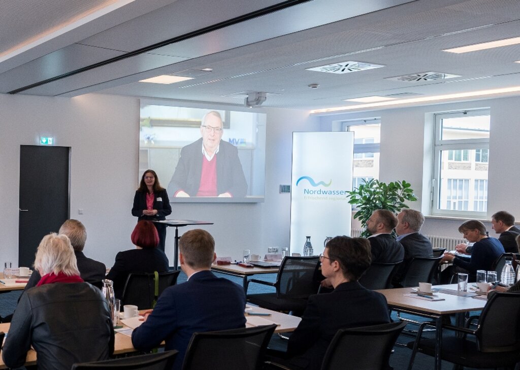 Tagungsraum in dem die Gäste sitzen, Frau Link hält einen Vortrag