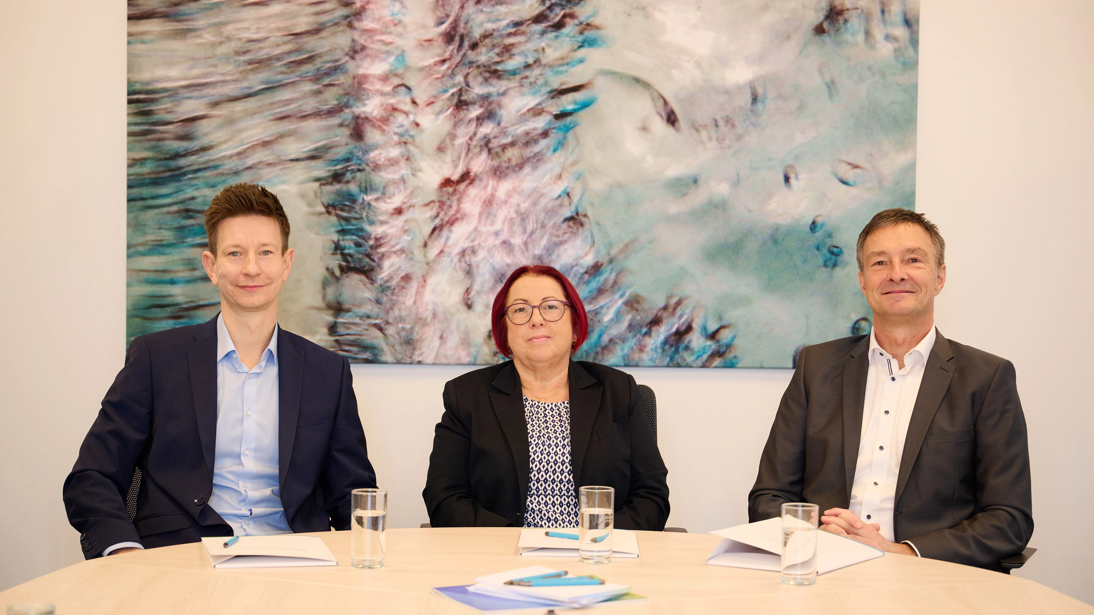 Die Geschäftsführer von Nordwasser und die Geschäftsführerin des WWAV sitzen an einem Tisch und schauen freundlich in die Kamera