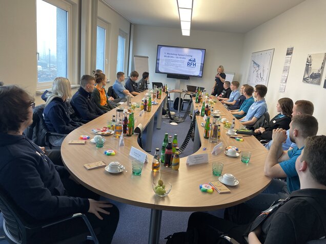 Azubis sitzen an einer Tafel