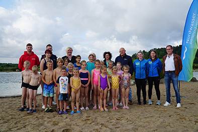 Gruppenbild vor einer Strandkulisse.