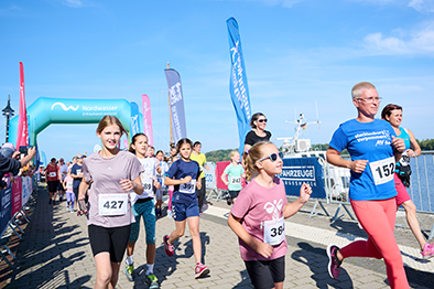 Kinder und Erwachsene auf der Strecke einer Laufveranstaltung.