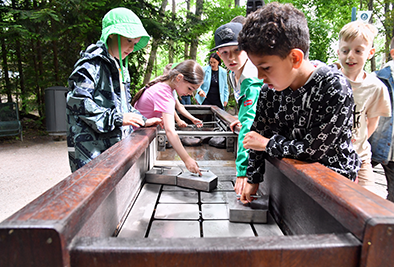 Kinder spielen an einem Wasserspielplatz im Zoo.